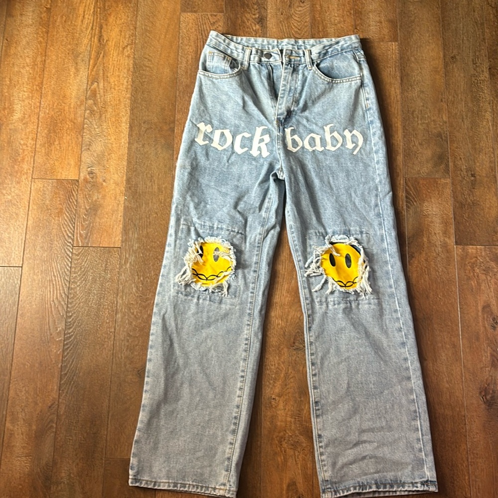 Denim jeans with emoji face and says rock baby